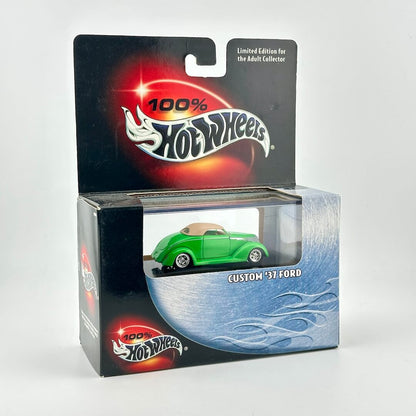 A Hot Wheels diecast car in its original retail packaging, featuring a green 1937 Ford custom car. 