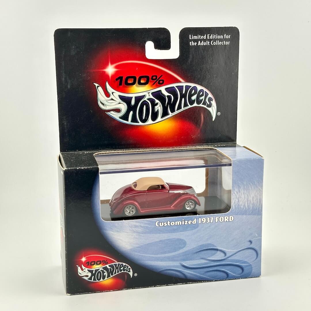 A Hot Wheels 'Customized 1937 Ford' die-cast toy car in its original packaging, featuring a dark red car.