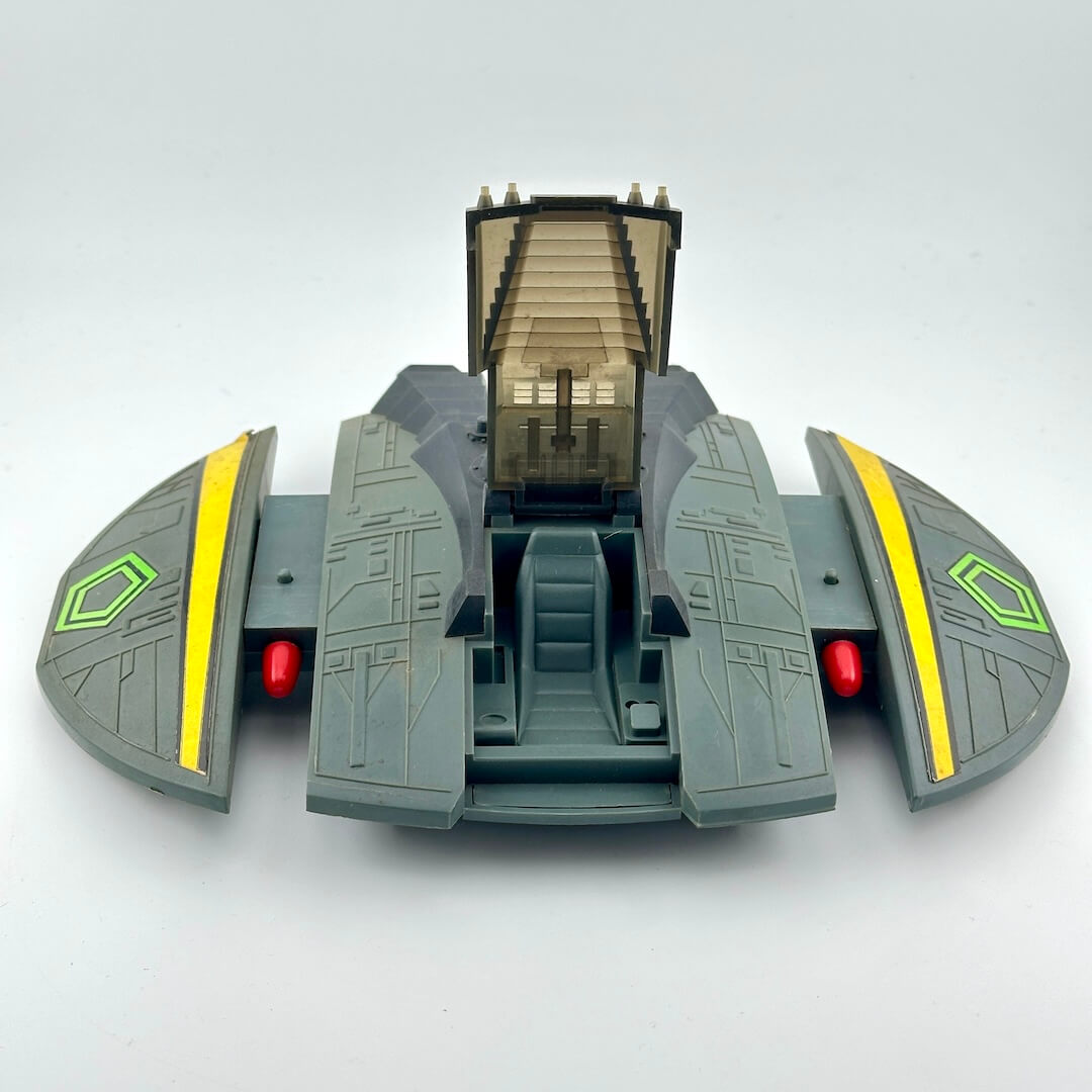 Toy spaceship model on a light gray background