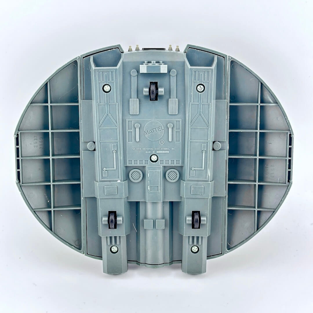 Gray toy model of a spaceship with visible branding on a white background