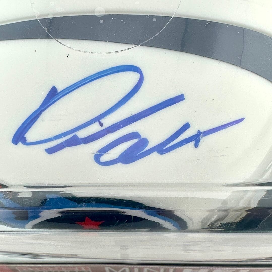Close-up of a signature on a sports helmet with a clear protective cover.