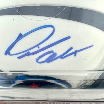 Close-up of a signature on a sports helmet with a clear protective cover.