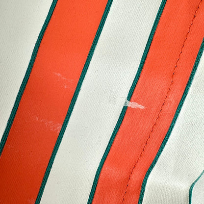 Close-up of a striped textile with alternating white and bright orange vertical stripes, showing a small white scratch.