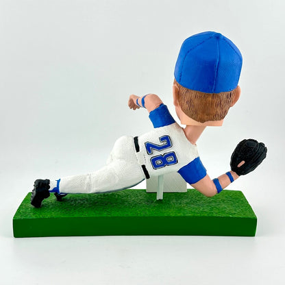 Bobblehead of a baseball player in a white and blue uniform with number 28 on a green base.