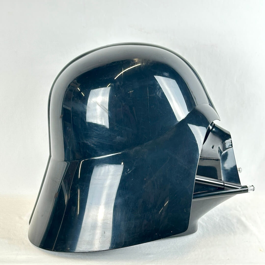 Side view of glossy black Darth Vader helmet on white background. Pictured without stand.