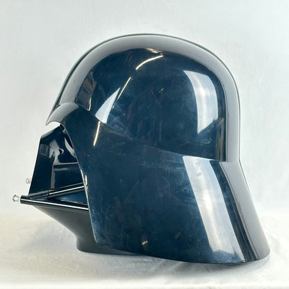 A glossy black Darth Vader helmet replica or costume headpiece, photographed against a light gray fabric backdrop.