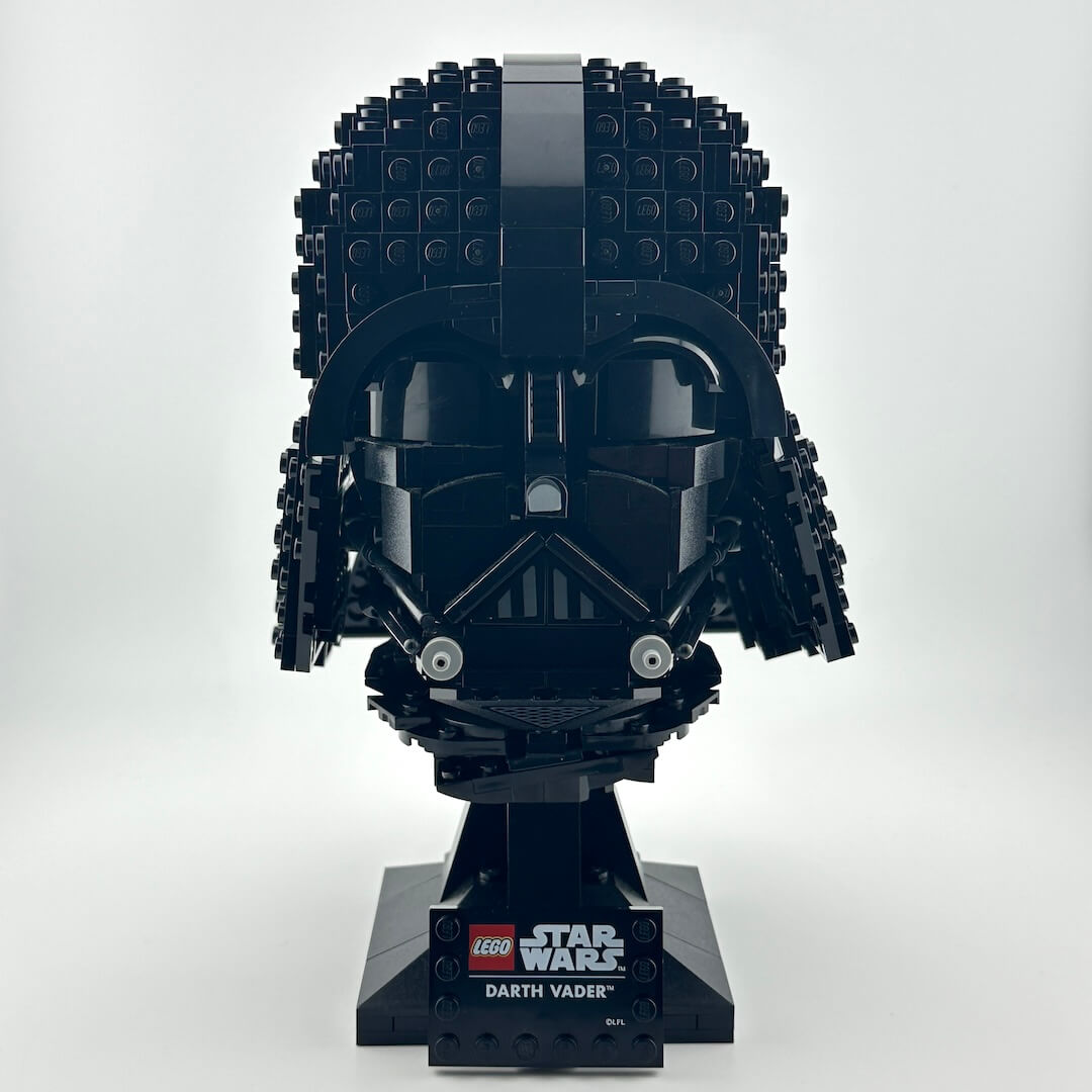 Darth Vader Lego helmet with stand against white background. 