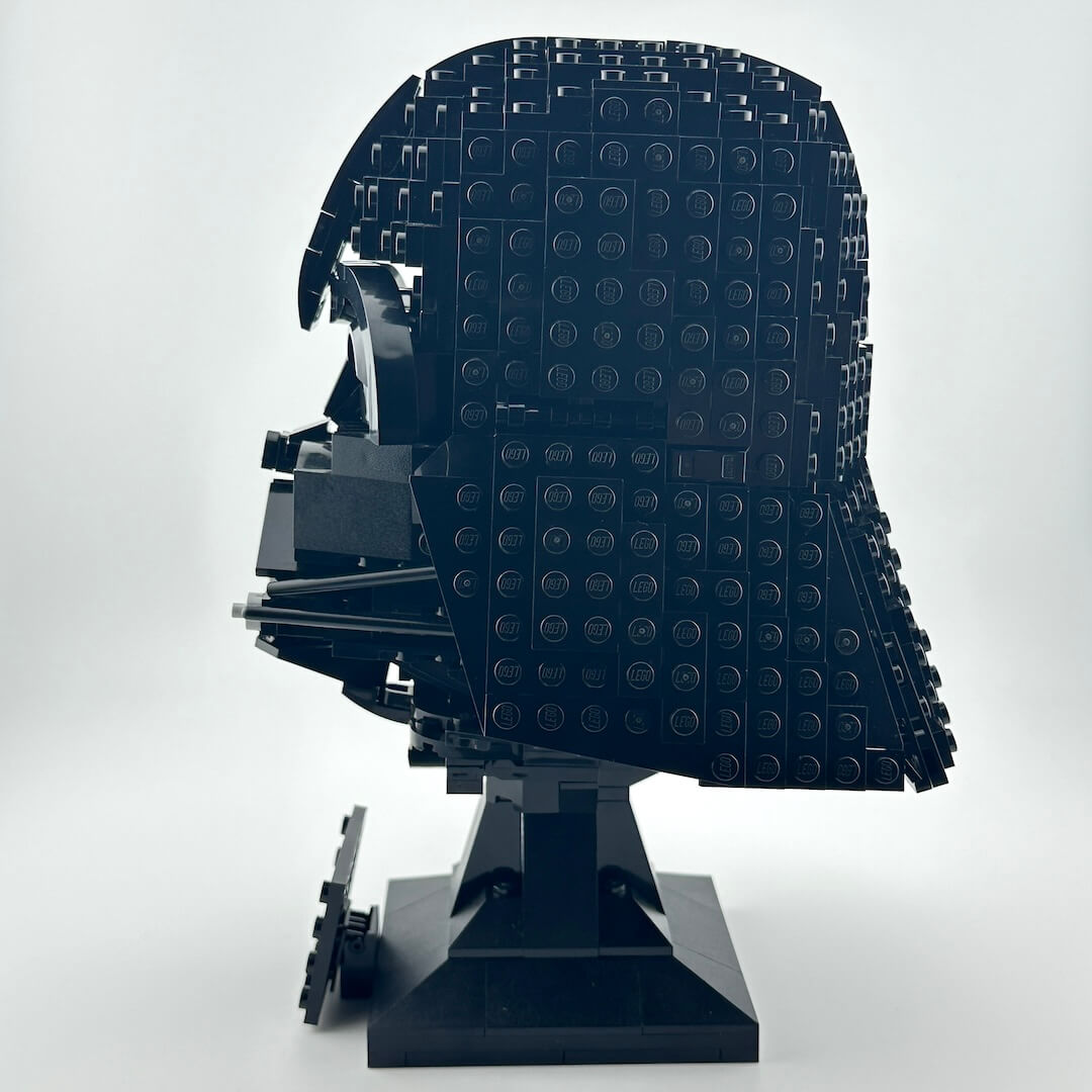 Darth Vader Lego helmet with stand against white background. 