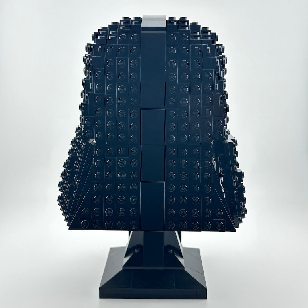 Darth Vader Lego helmet with stand against white background. 