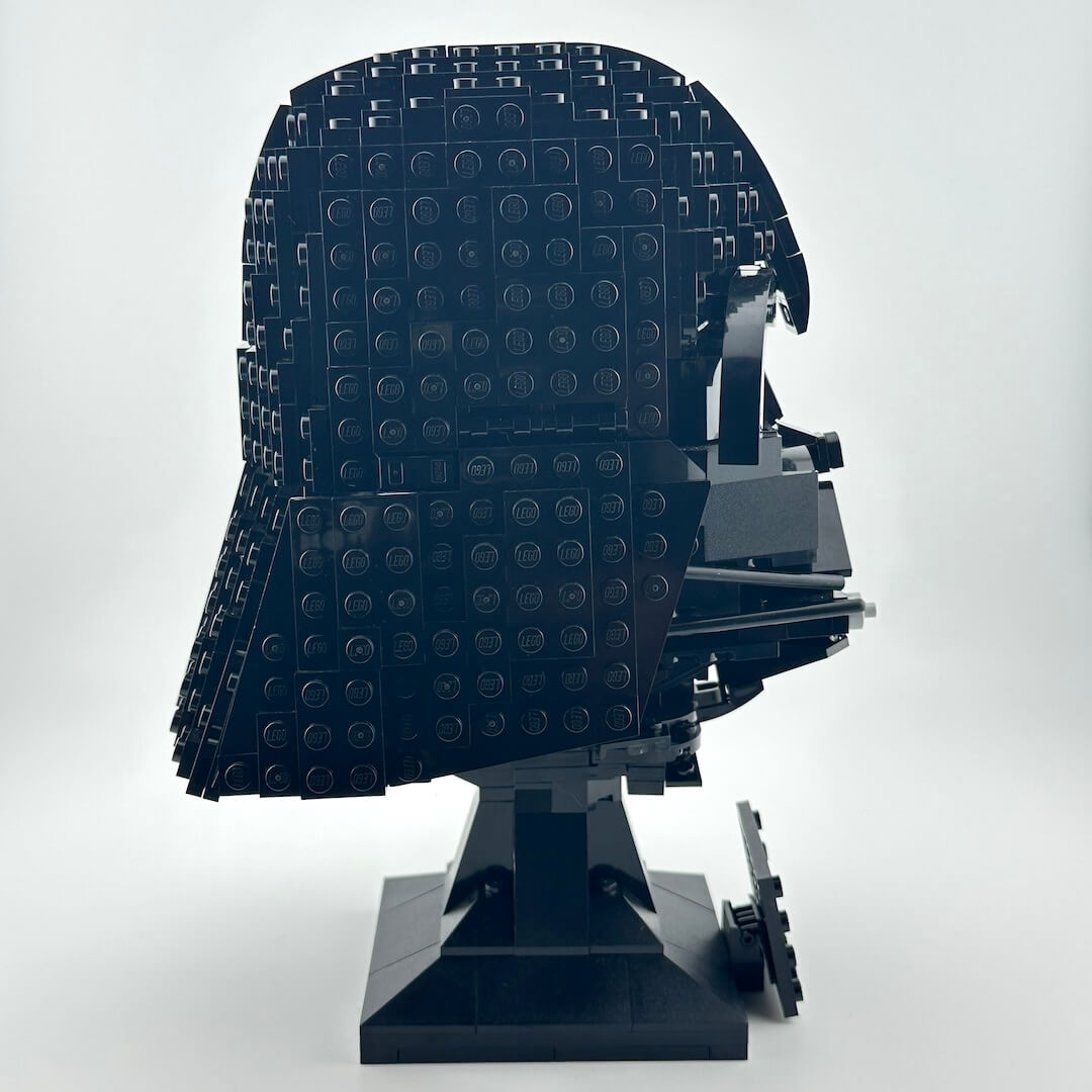 Darth Vader Lego helmet with stand against white background. 