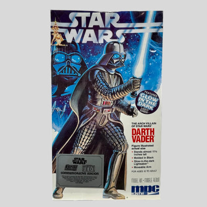 Box with Darth Vader holding blue lightsaber in fighting pose in front of galaxy graphic with STAR WARS logo at top.