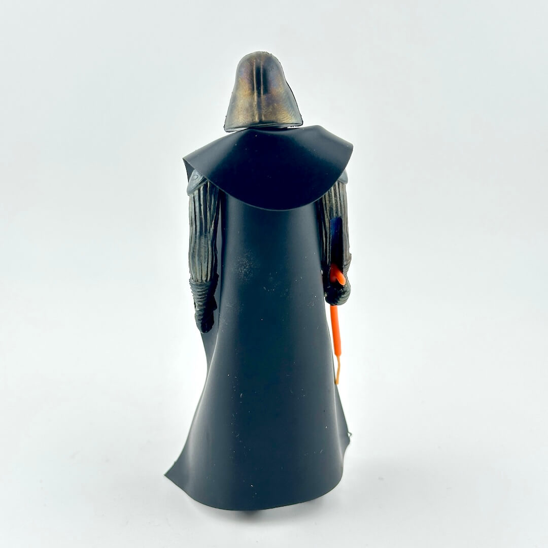 Action figure in black with black cloak and orange lightsaber on white background. 