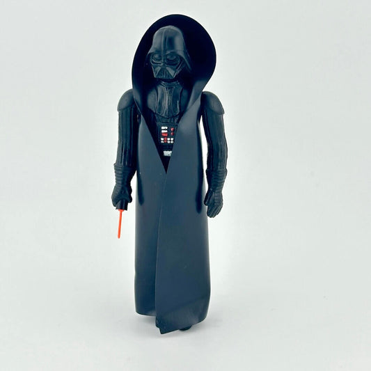 Toy figure of a character in dark costume with a red light saber on a white background