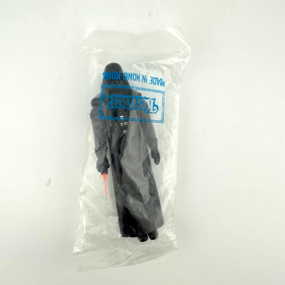 Darth Vader action figure in clear plastic bag with "Kenner" branding printed on bag, against white background.