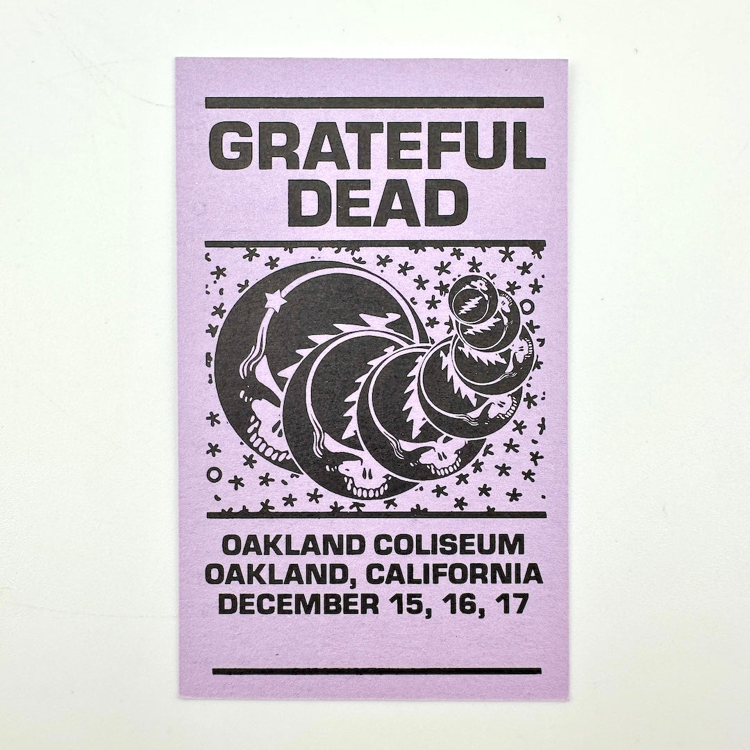 Purple rectangular card with "Grateful Dead" text at top with event dates along the bottom, central image of stealies. 