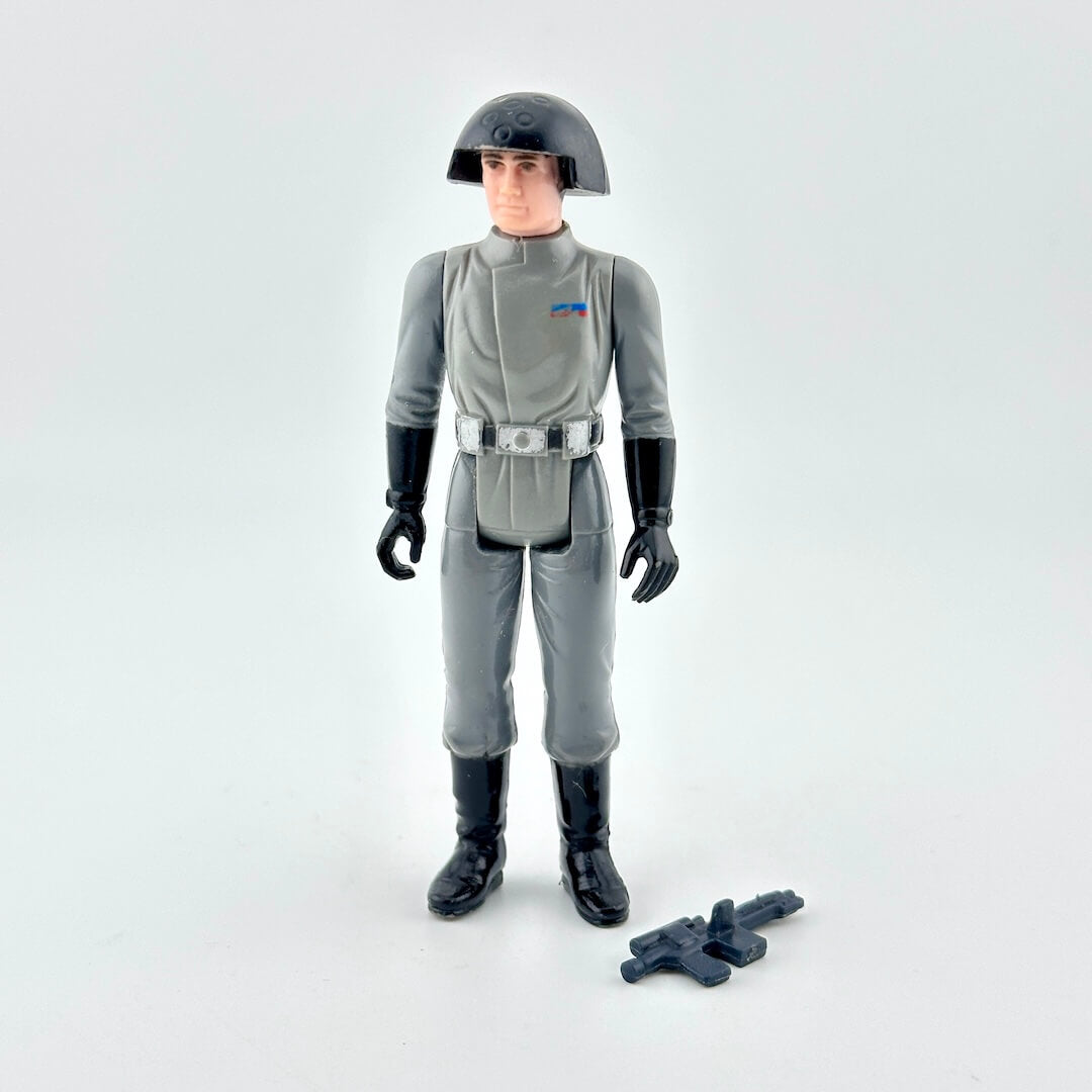 Action figure in gray military uniform with helmet and weapon on white background. 