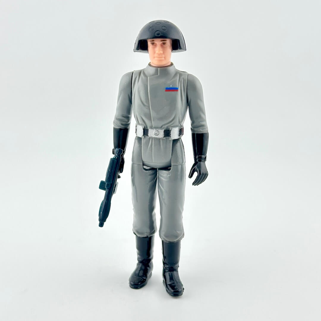 Action figure in gray uniform with helmet and weapon on a white background