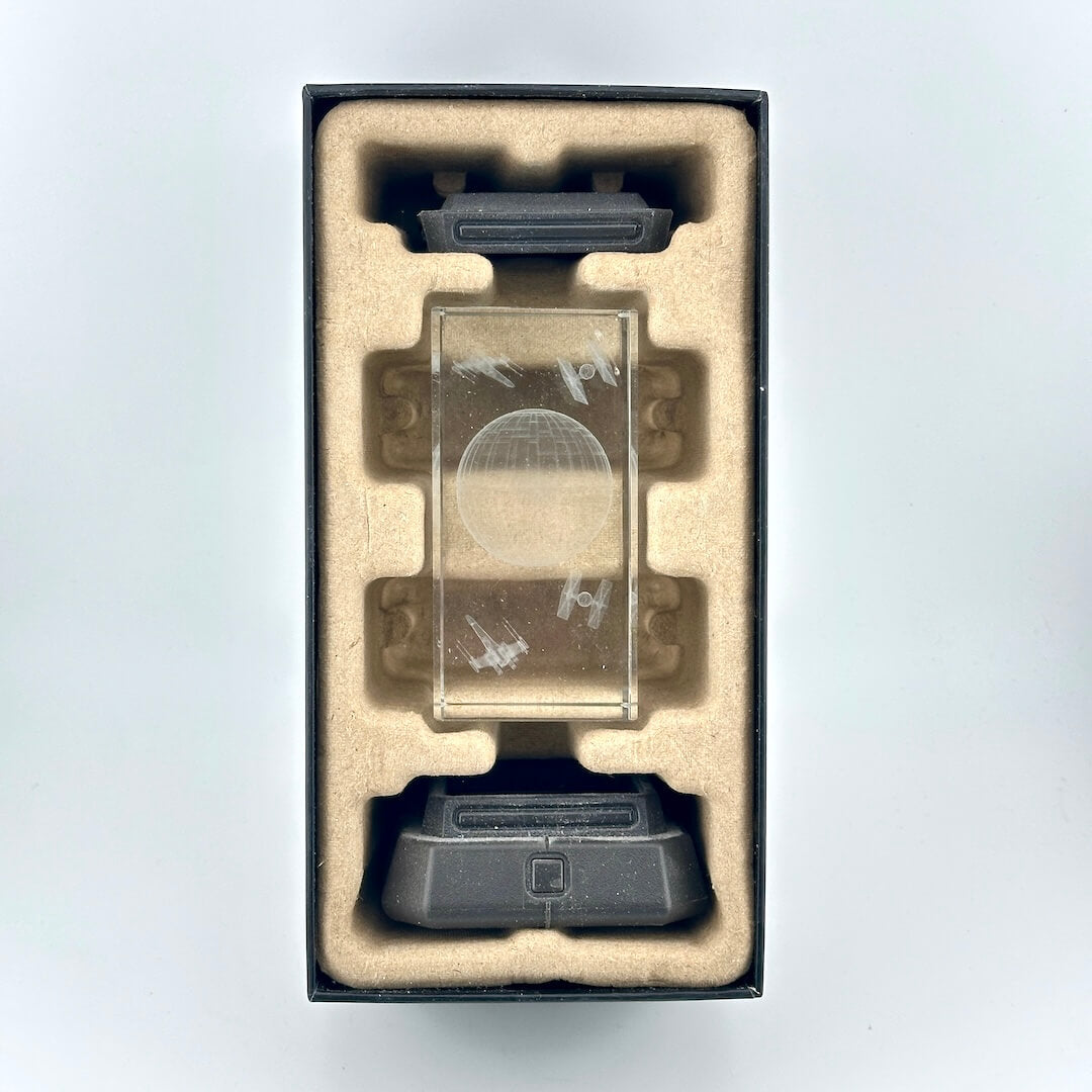 Interior contents of retail box for Death Star Light, showing base, top, and etched crystal middle pieces. 