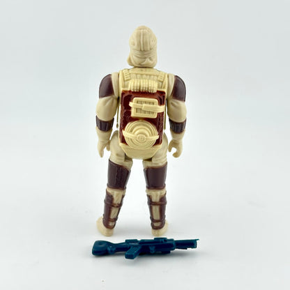 Action figure shown from the back, featuring a tan and dark brown armored design with a blue toy rifle accessory.