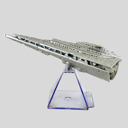 A gray miniature model of a sci-fi spaceship displayed on a clear acrylic pyramid stand against a white background.