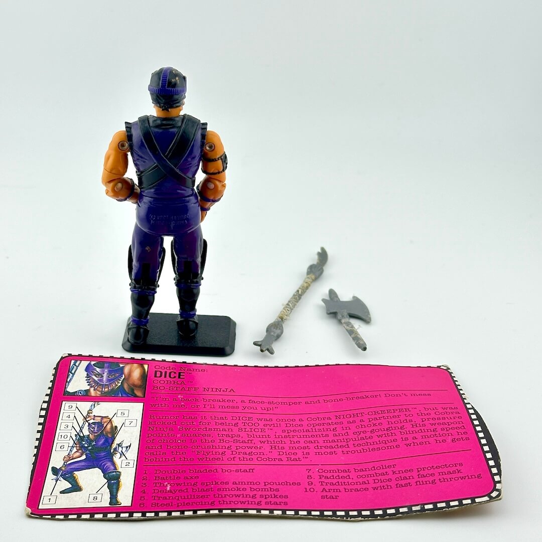 Toy figure with accessories and a pink card on a white background