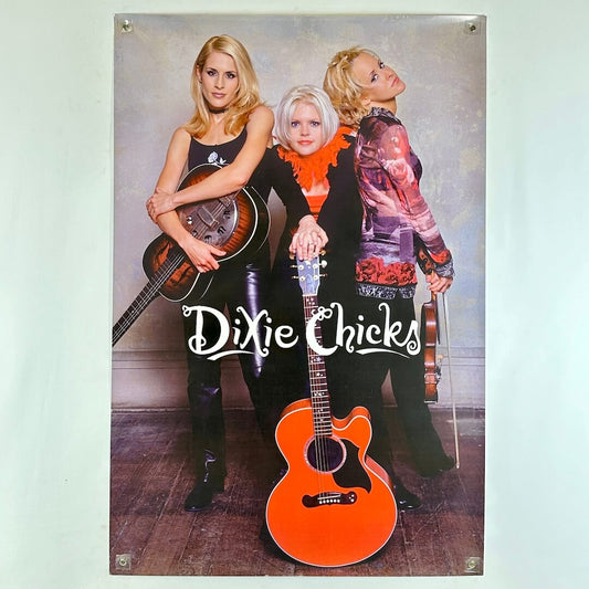 Poster of three women holding guitars with 'Dixie Chicks' branding.