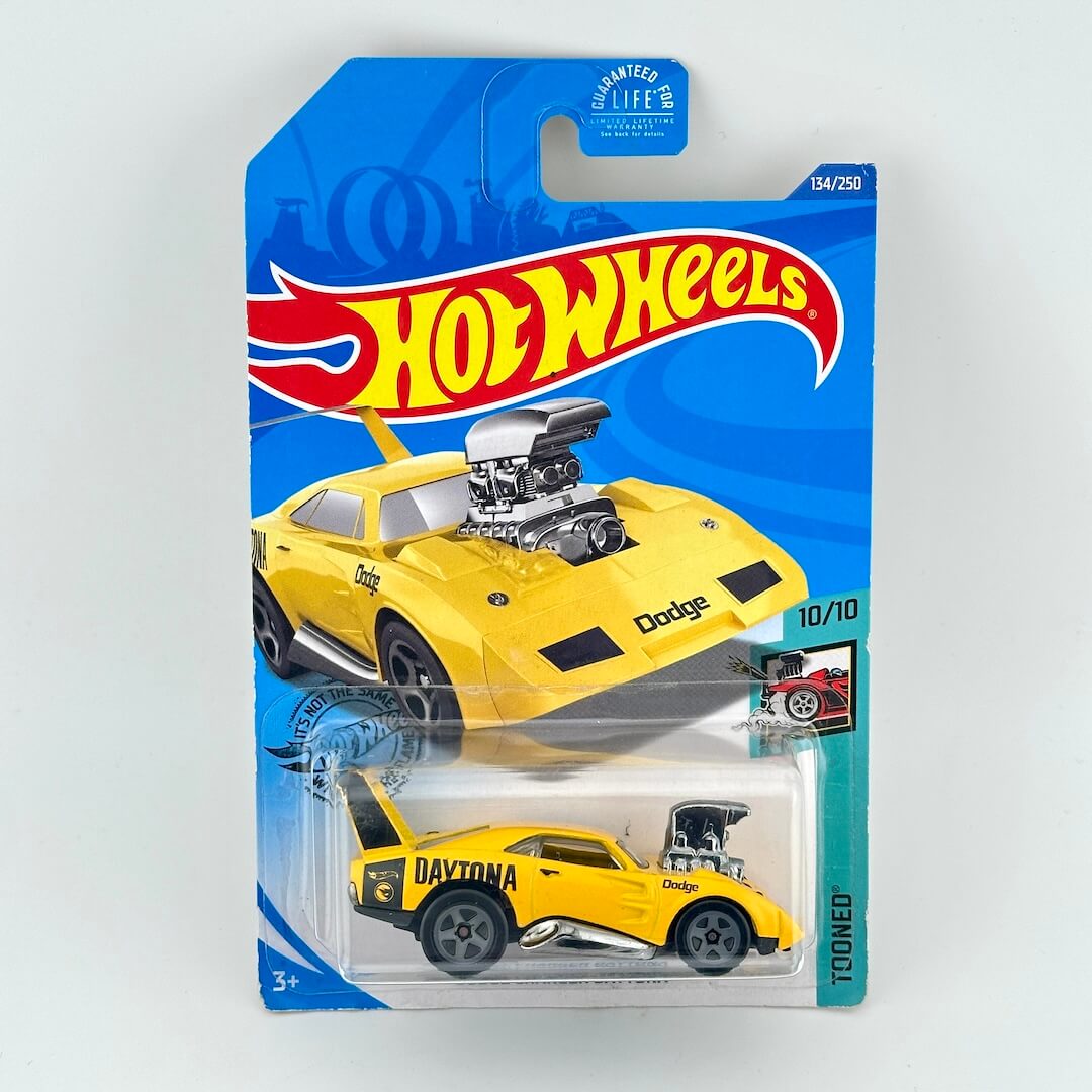 A Hot Wheels diecast toy car in its original blister card packaging, featuring a yellow muscle car.