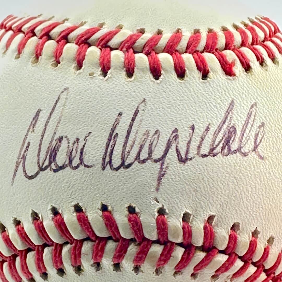 Close-up of a baseball with red stitching and a signature on a white background