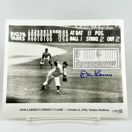 Black and white photo of Don Larsen pitching a perfect game with scoreboard and signature on display.