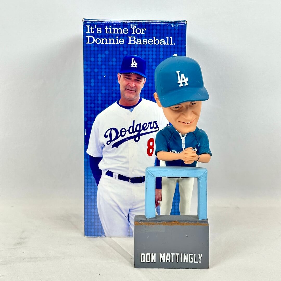 A Don Mattingly Los Angeles Dodgers bobblehead figurine standing in front of its original blue packaging box.