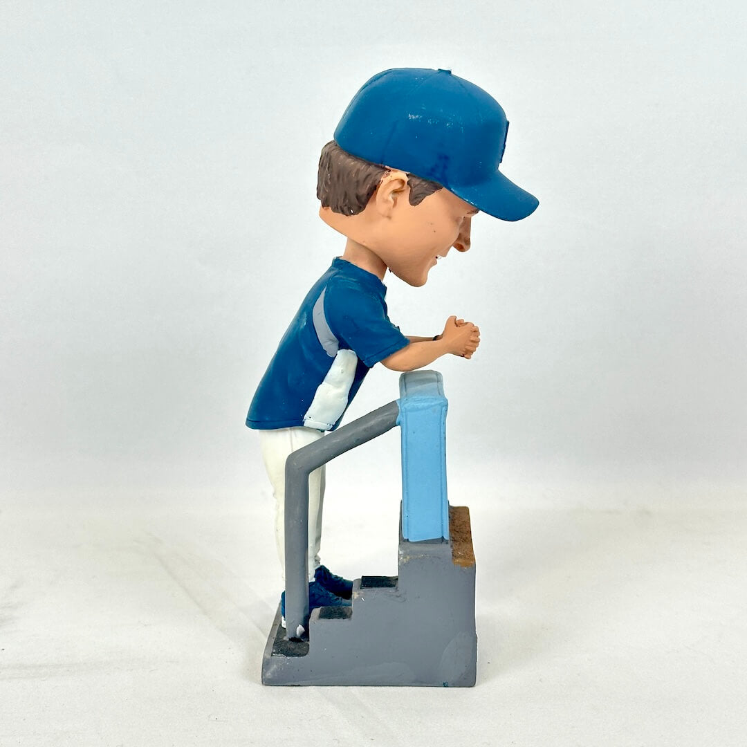 A hand-painted bobblehead figurine of a baseball player in a blue jersey and cap.
