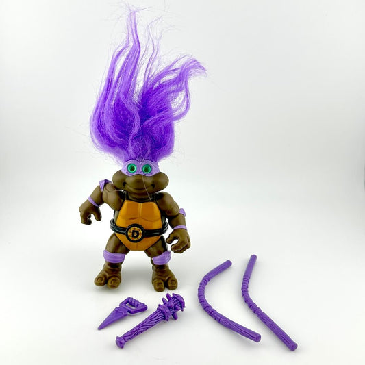 Toy figure with purple hair and accessories on a white background