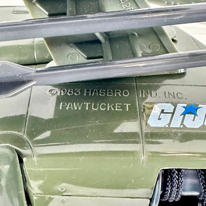 Close-up of a green toy vehicle body with visible Hasbro and GI Joe logo markings, plus a dark gray missiles.
