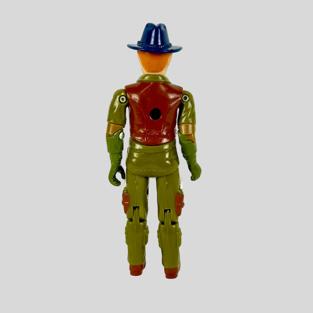A vintage plastic action figure shown from the back, featuring olive green flight suit and blue hat. 