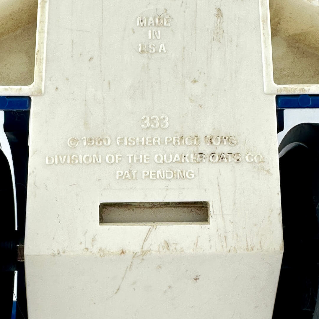 Close-up of the side of a vintage cream-colored plastic showing embossed text including 'MADE IN U.S.A'