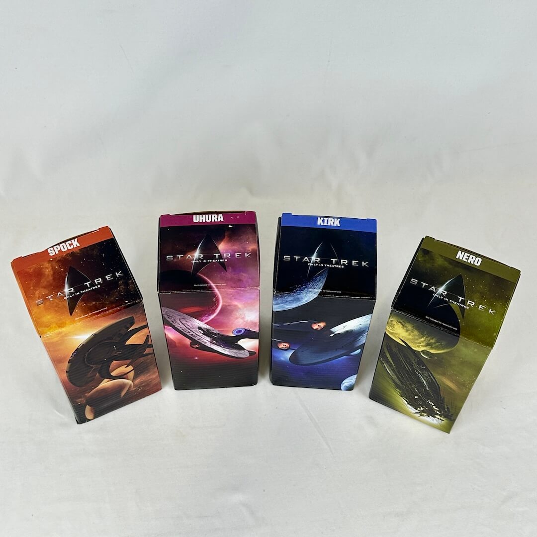 Four colorful boxes with spaceship graphics against white background. View of the tops.