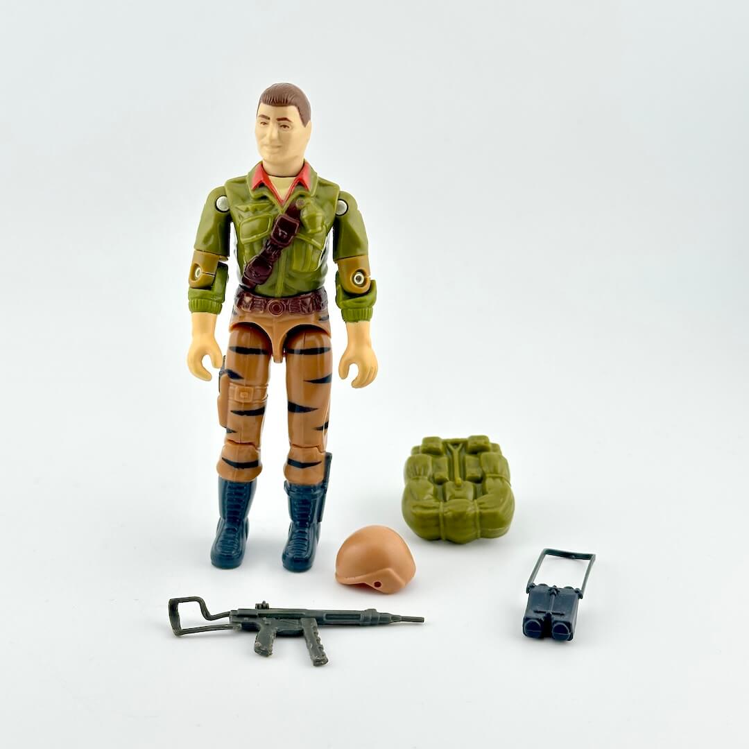 GI Joe action figure with accessories against white background. 