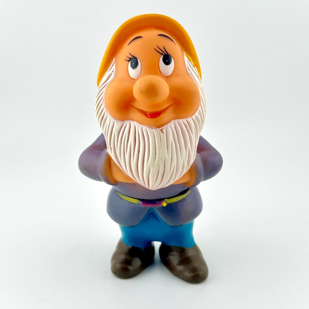 Toy figure of a character with a white beard and orange hat on a white background
