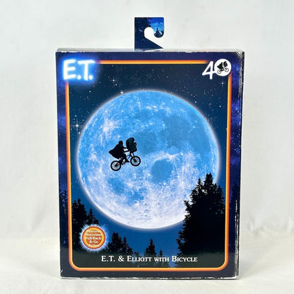 E.T. toy packaging with E.T. and Elliott on a bicycle against a moonlit sky.