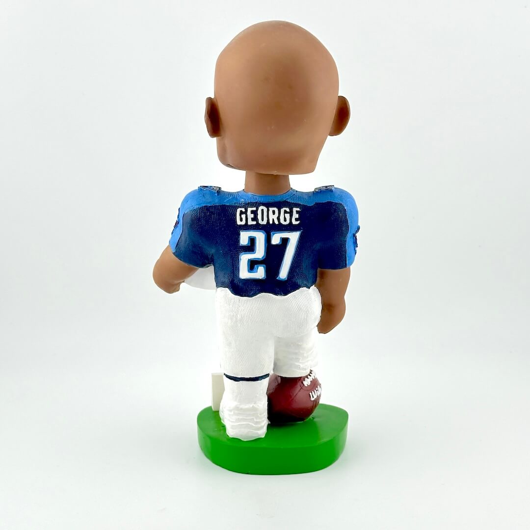Bobblehead of football player holding helmet against white background. 