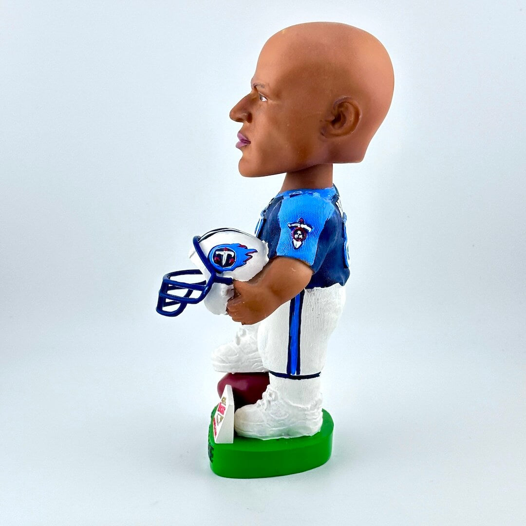 Bobblehead of football player holding helmet against white background. 