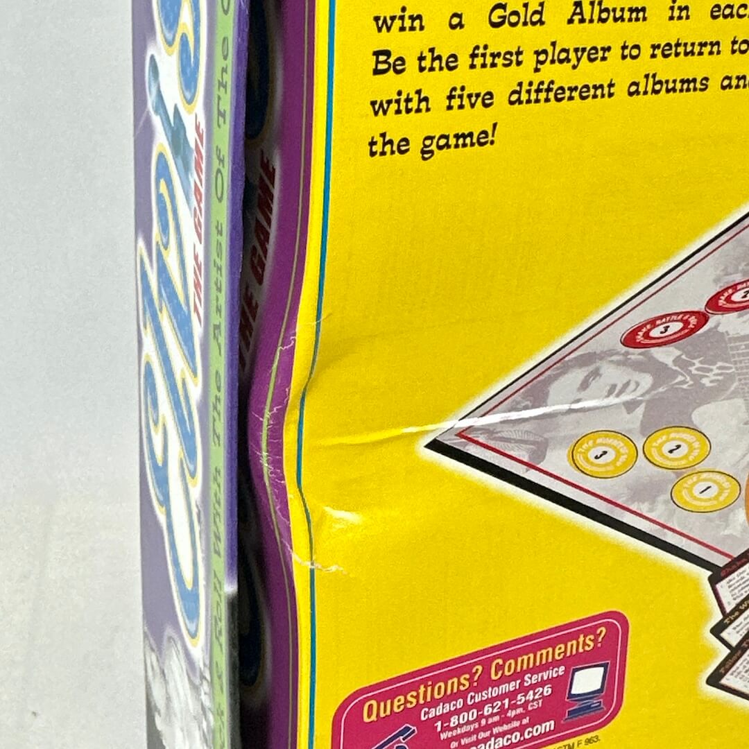 Close-up of a card game box with text and a card featuring a face.