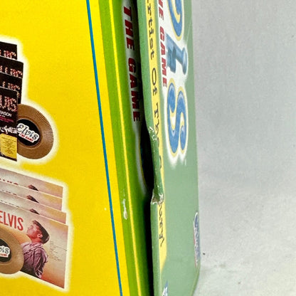 Close-up of a 'Elvis' game box with a yellow and green design on a gray background
