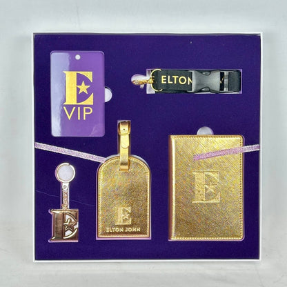Gold luggage tags and a card with 'Elton John' branding on a purple background