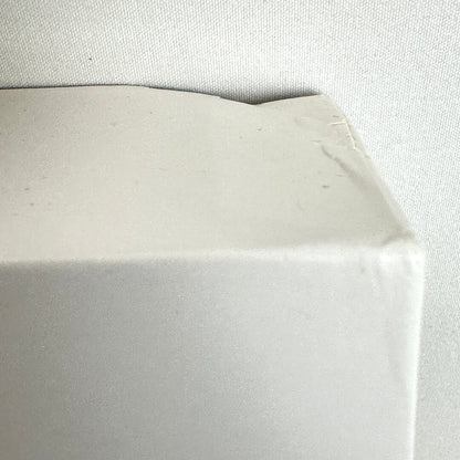 Top right corner of box with dent. 