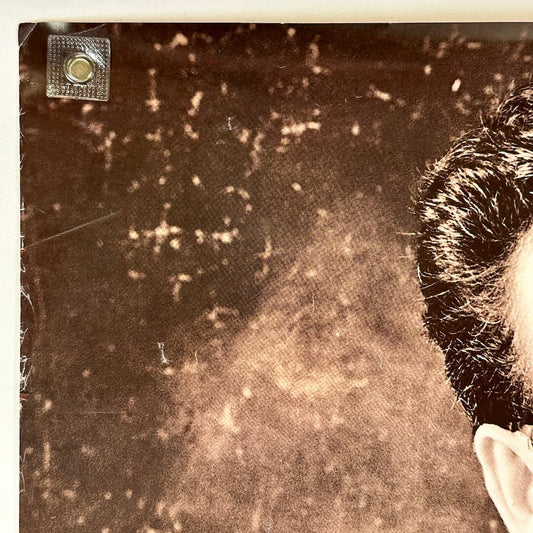 Top left corner of poster with wear along left edge. 