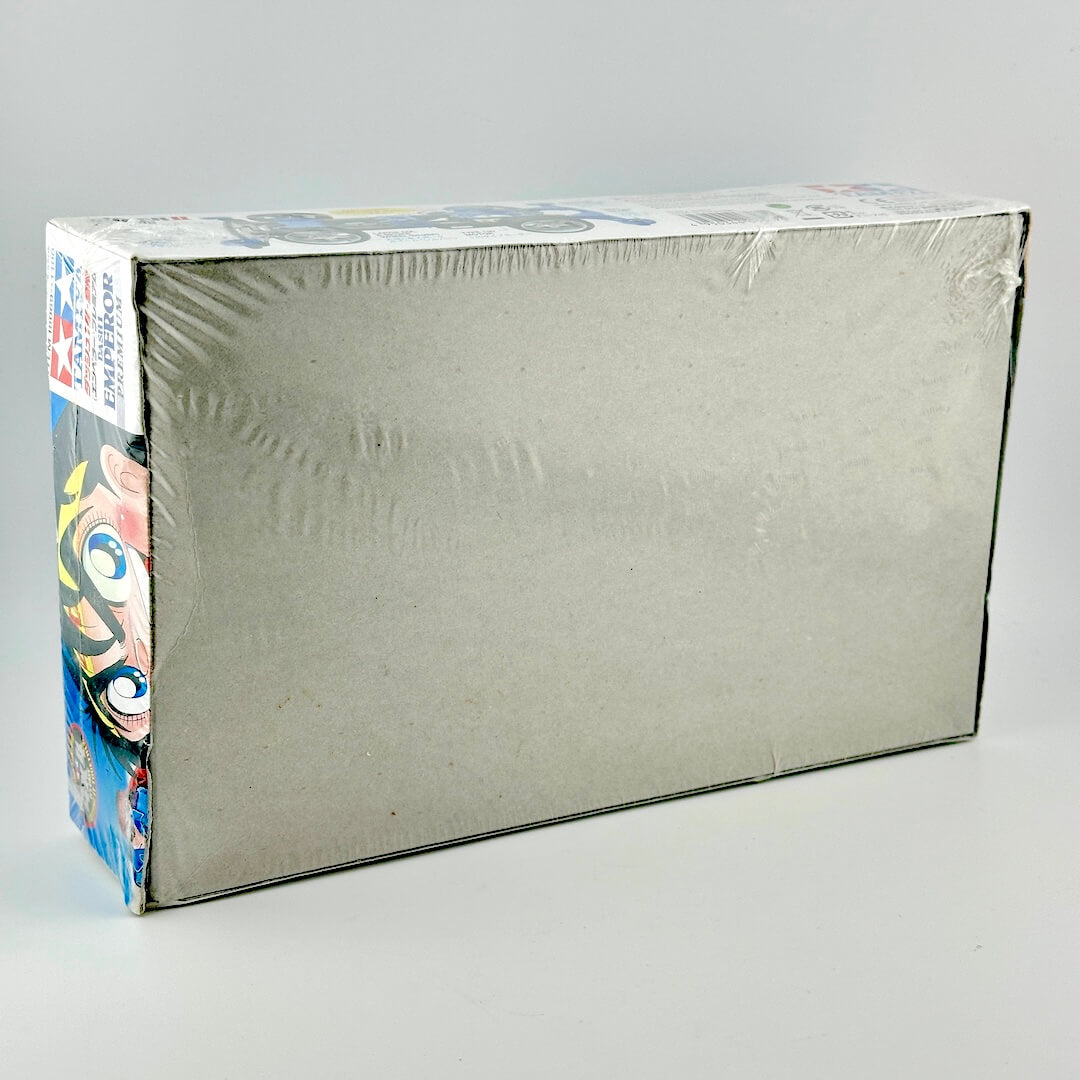 Back view of packaging showing cardboard box wrapped in plastic. 