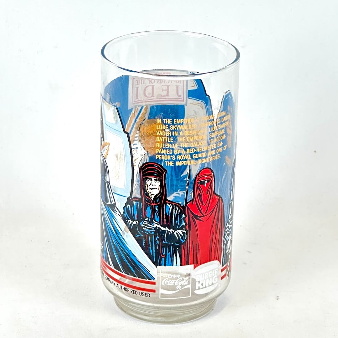 Drinking glass with Star Wars-themed design featuring characters and text on a white background