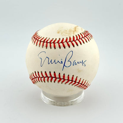 Baseball with autograph in sweet spot on clear stand against white background. 