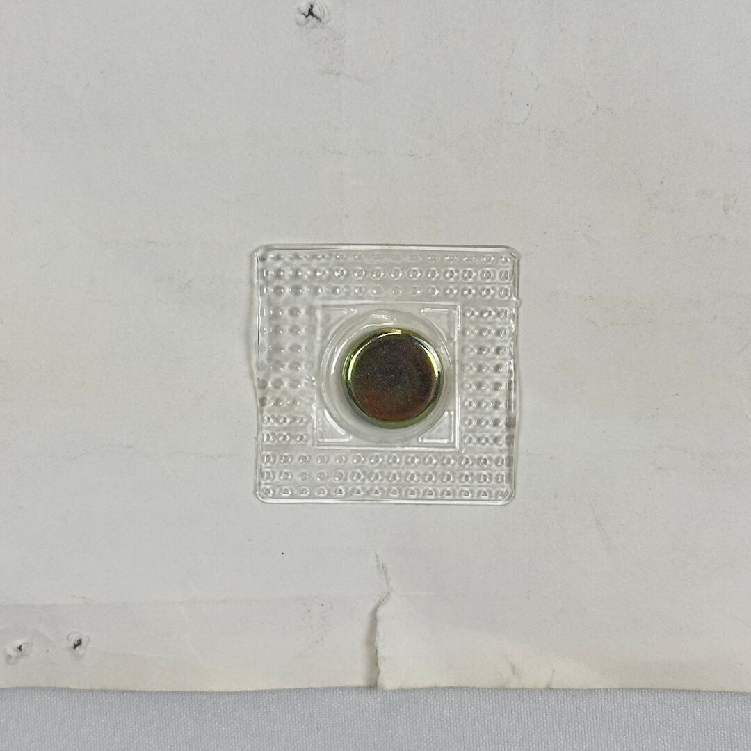 Close up of tear at bottom center of poster, about a quarter inch in length.